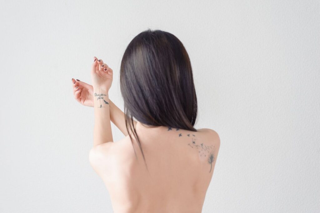 tatouage pissenlit sur le dos d'une femme