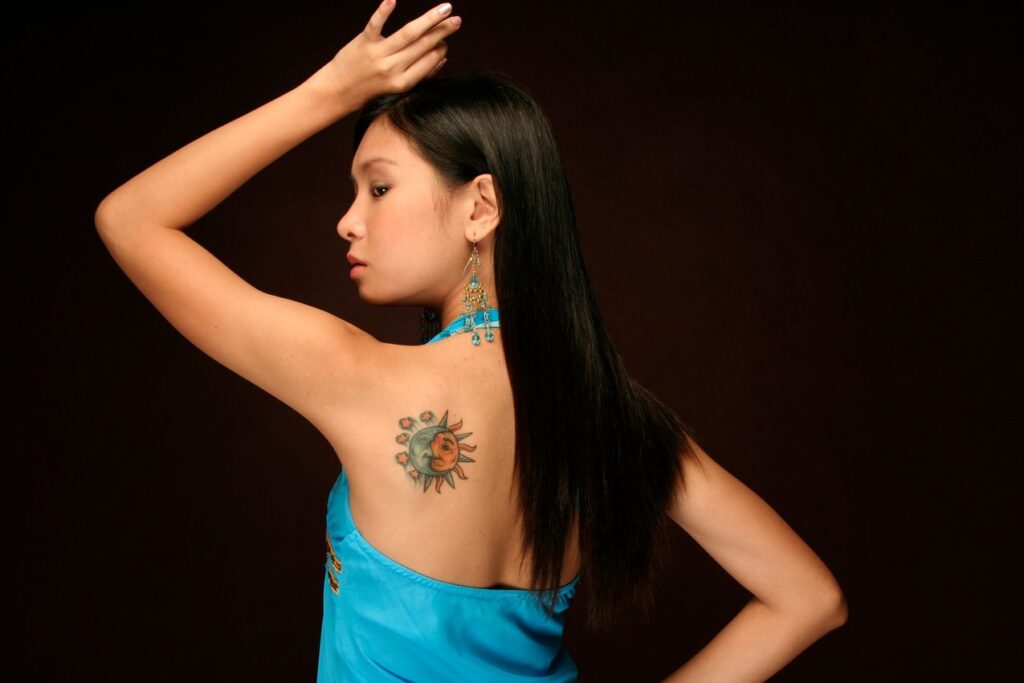 Tatouage lune et soleil sur l'homoplate d'une femme