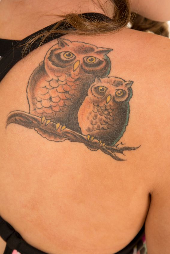 tatouage hibou sur le dos d'une femme