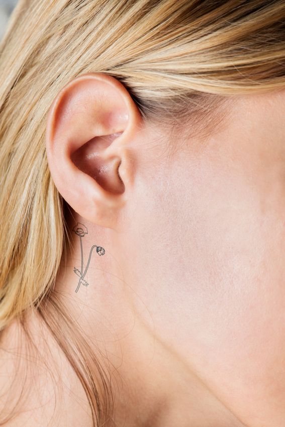 Tatouage petite fleurs derrière l'oreille