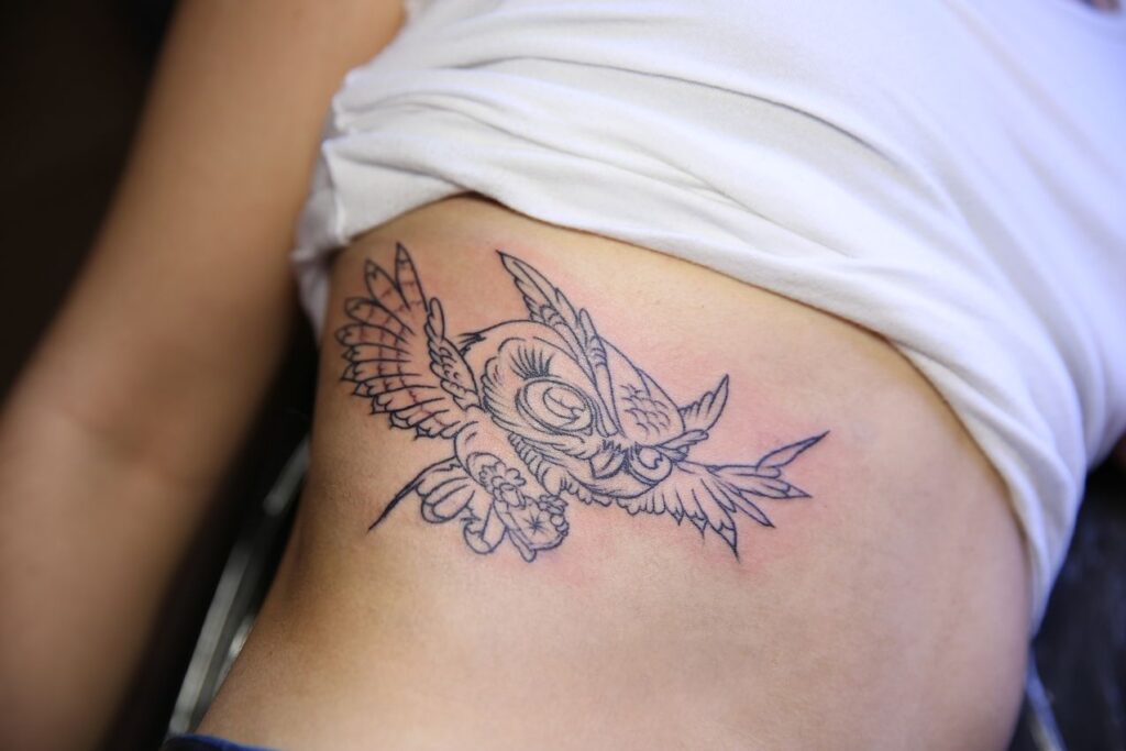 Tatouage Hibou sous les sein d'une femme