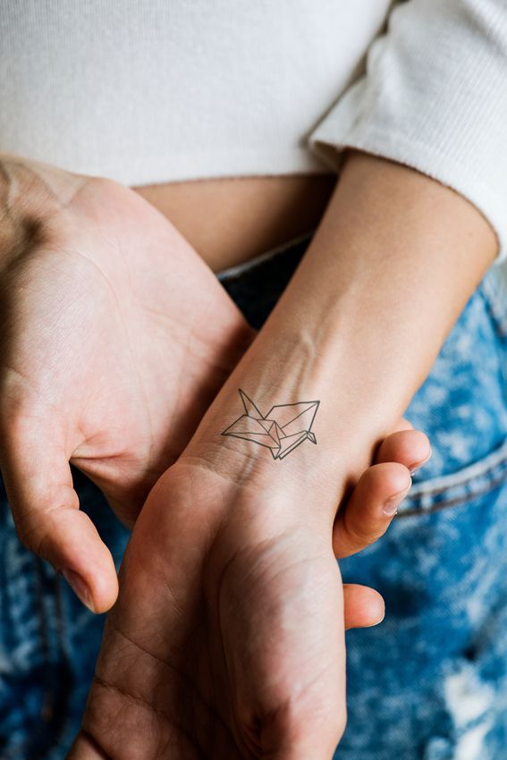 Tatouage style origami oiseau sur le poignet