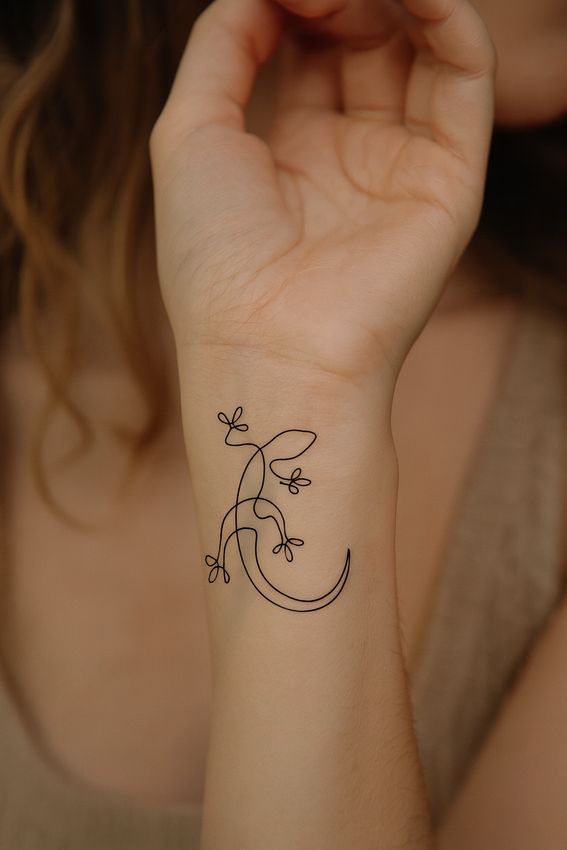 tatouage salamandre minimaliste sur le poignet